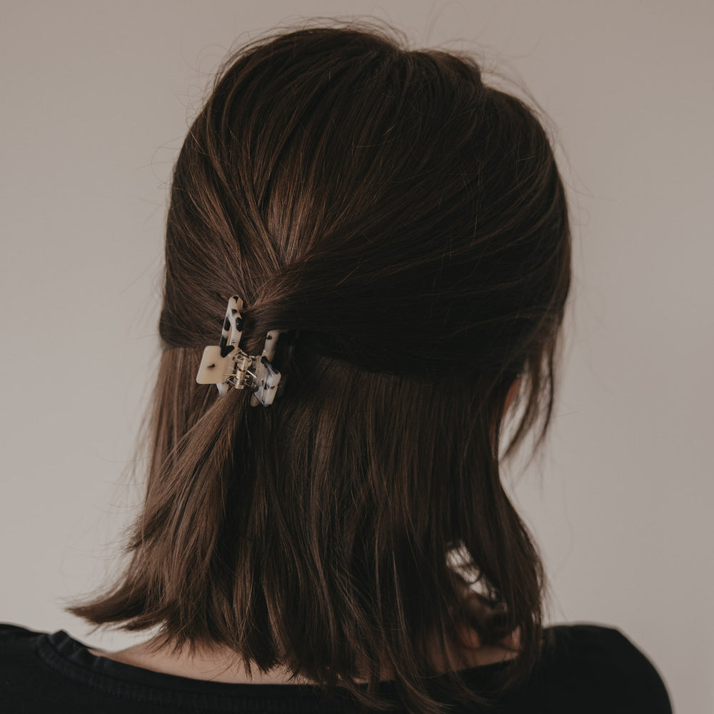 Rückansicht Frisur mit kleiner eckiger Haarspange im Leo-Design