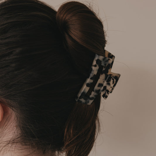 Detail der großen eckigen Haarspange im Leo-Design im Dutt getragen