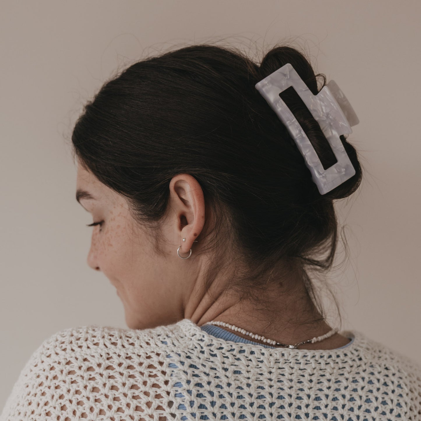 Maxi eckige Haarspange in Perlmutt-Optik hält Dutt im braunen Haar von hinten