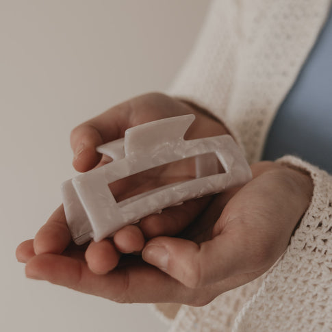 Maxi eckige Haarspange in Perlmutt-Optik in der Hand präsentiert