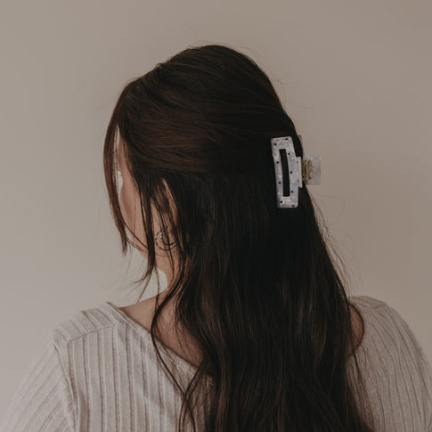 Große eckige Haarspange mit schwarzen Herzen hält halboffenes Haar von hinten