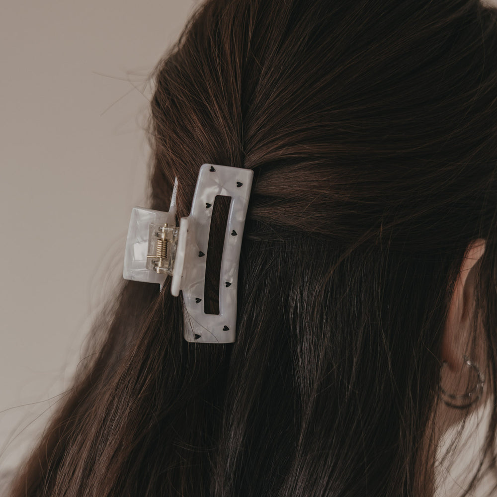 Detail der großen Haarspange eckig in Perlmutt-Optik mit schwarzen Herzen im Haar