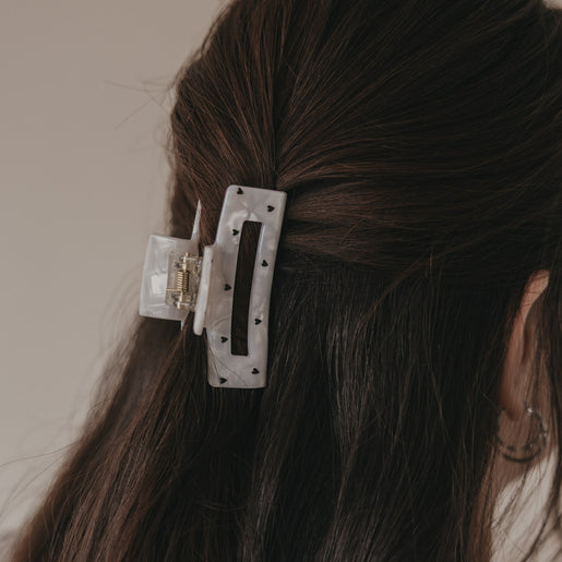 Detail der großen Haarspange eckig in Perlmutt-Optik mit schwarzen Herzen im Haar