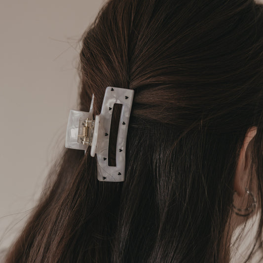 Detail der großen Haarspange eckig in Perlmutt-Optik mit schwarzen Herzen im Haar