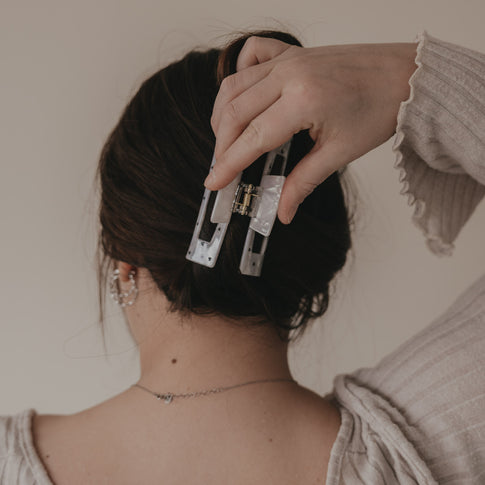 Hand öffnet maxi eckige Haarspange mit schwarzen Herzen am Hinterkopf