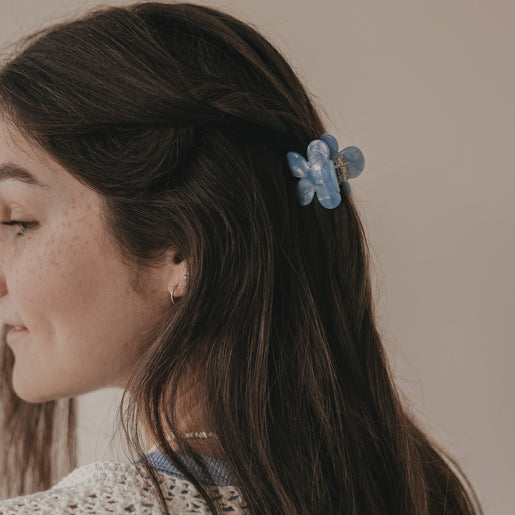 Haarspange Blume hellblau hält halboffenes Haar seitlich zusammen