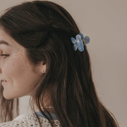 Haarspange Blume hellblau hält halboffenes Haar seitlich zusammen