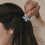 Haarspange Blume hellblau im Haar von hinten mittig getragen