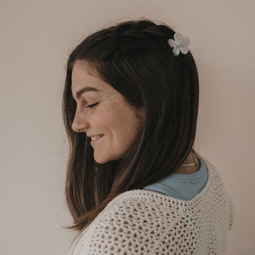 Haarspange Blume in Perlmutt-Optik im halboffenen braunen Haar von hinten getragen