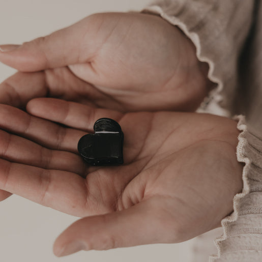 Kleine Haarspange in Herzform schwarz in der Hand präsentiert