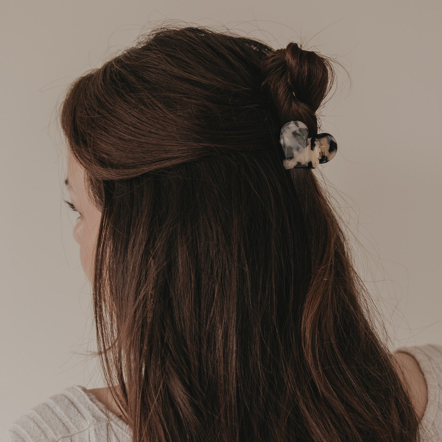 Große Haarspange in Herzform mit Leo-Muster im halboffenen braunen Haar getragen