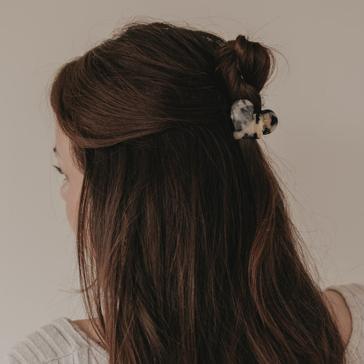 Große Haarspange in Herzform mit Leo-Muster im halboffenen braunen Haar getragen