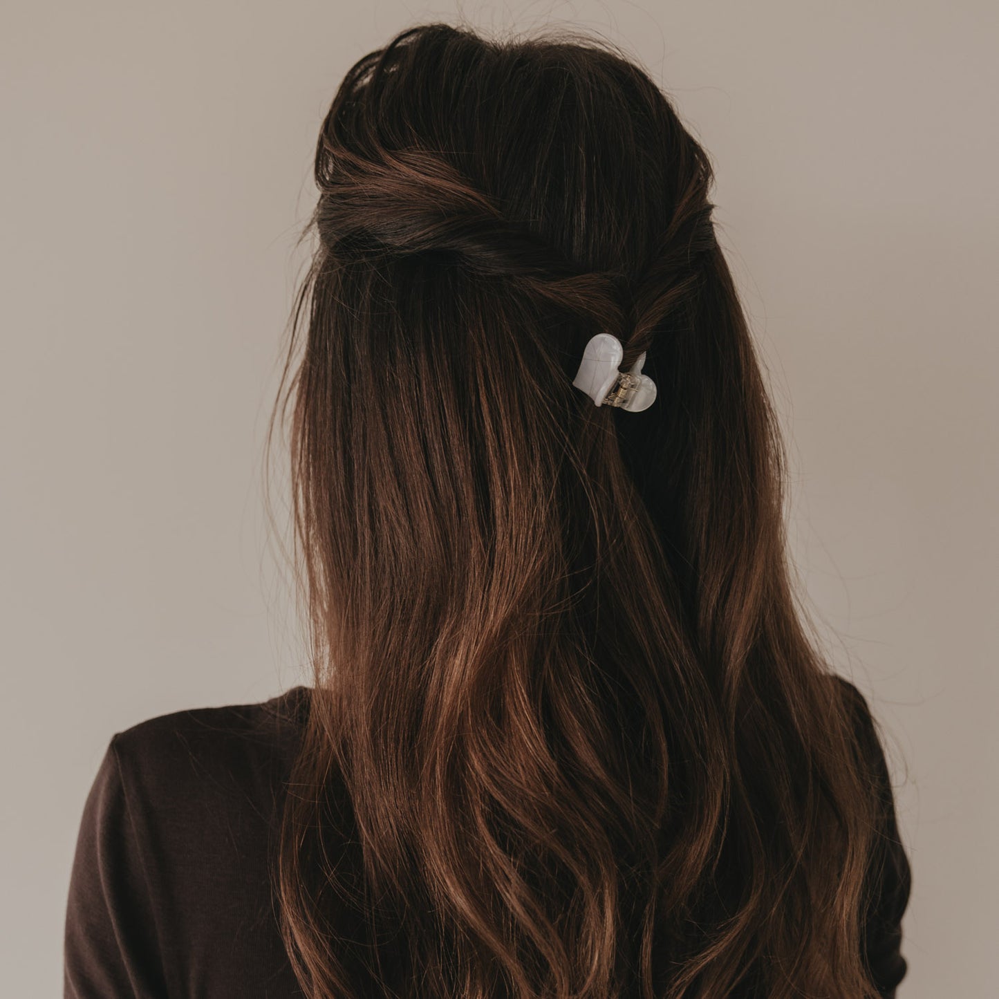 Kleine Haarspange in Herzform Pearl im halboffenen braunen Haar getragen