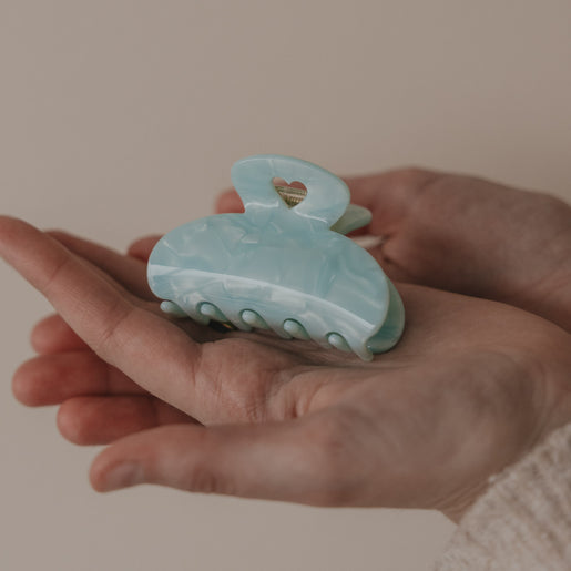 Große Haarspange Mint mit Herzdetail als Produkt in der Hand präsentiert