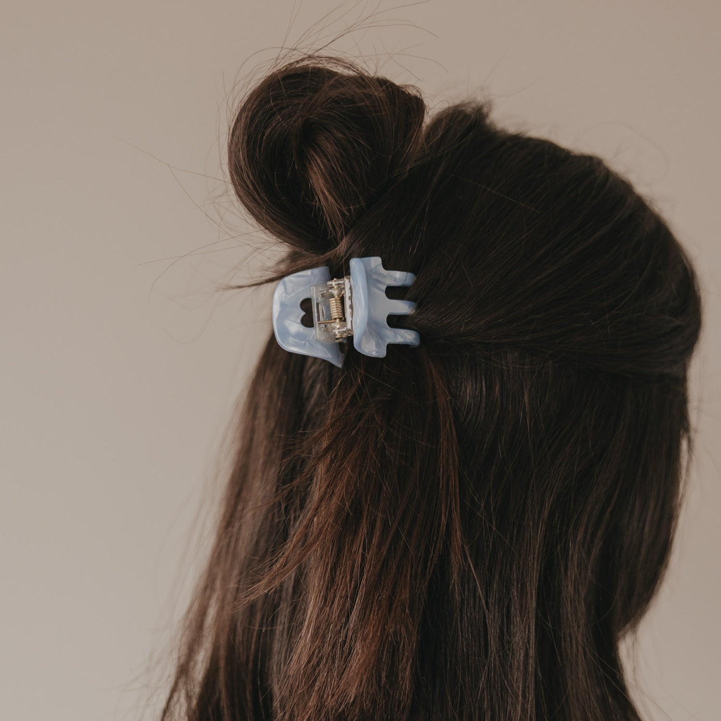 Rückansicht halboffene Frisur mit kleiner Haarspange Blau Herzdetail