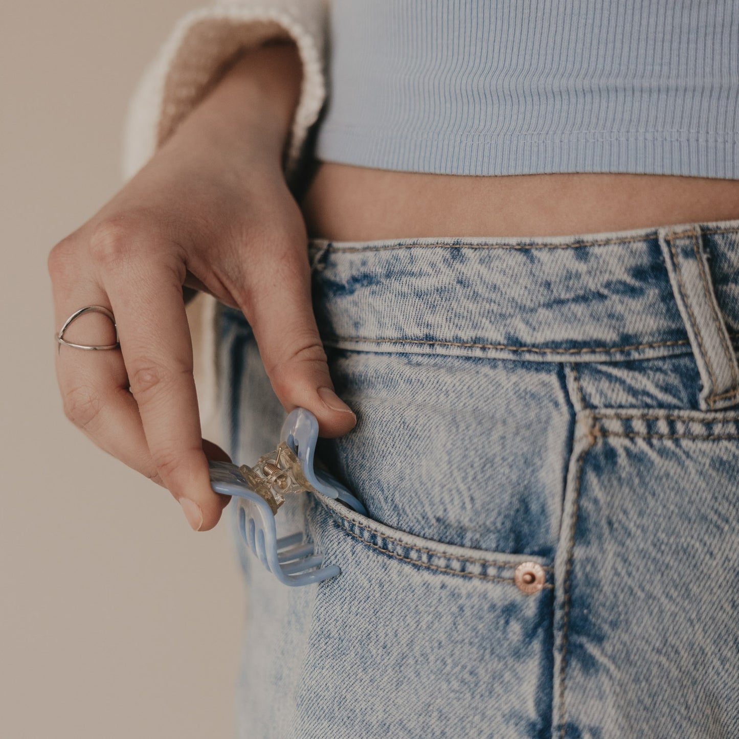 Kleine blaue Haarspange als Accessoire an Jeans getragen