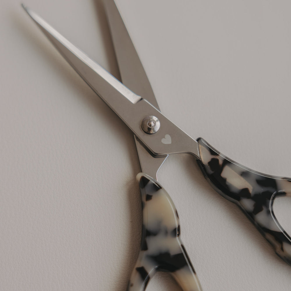 Silberne Schere mit Griff im Leo-Design und kleinem Herzdetail als Nahaufnahme