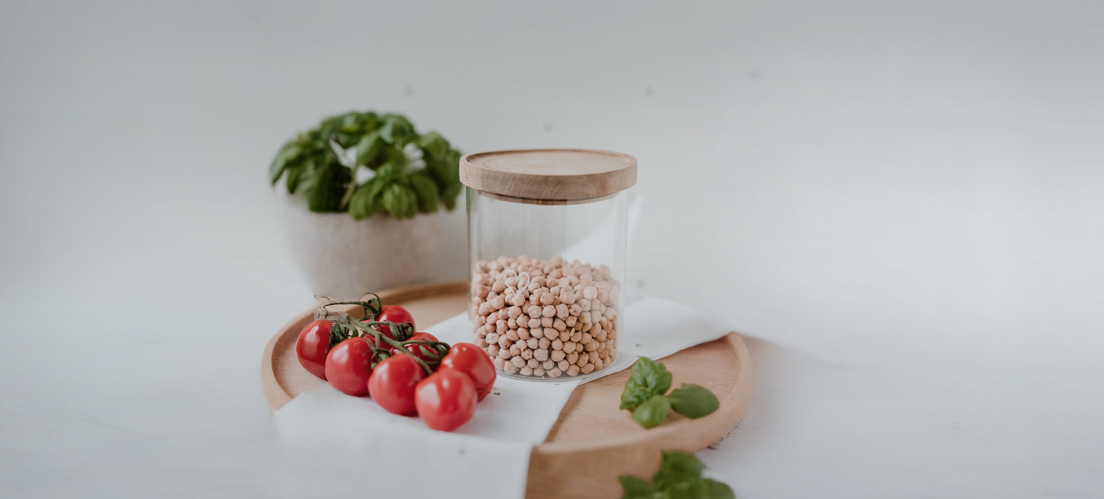 Gratis Vorratsglas (wahlweise 13 cm oder 19 cm) bei einem Bestellwert ab 40 € mit dem Code „LIEBLINGSGLAS“. Gültig vom 08.08. bis 10.08.2024. Nicht kombinierbar mit anderen Rabatten. Abgebildet ist ein Vorratsglas mit Holzdeckel, gefüllt mit Kichererbsen, auf einem Holztablett mit frischen Tomaten und Basilikum.