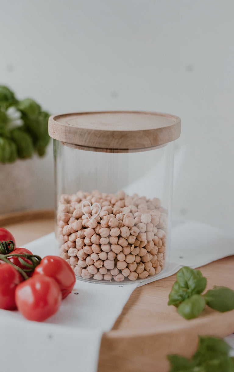 Gratis Vorratsglas (wahlweise 13 cm oder 19 cm) bei einem Bestellwert ab 40 € mit dem Code „LIEBLINGSGLAS“. Gültig vom 08.08. bis 10.08.2024. Nicht kombinierbar mit anderen Rabatten. Abgebildet ist ein Vorratsglas mit Holzdeckel, gefüllt mit Kichererbsen, auf einem Holztablett mit frischen Tomaten und Basilikum.