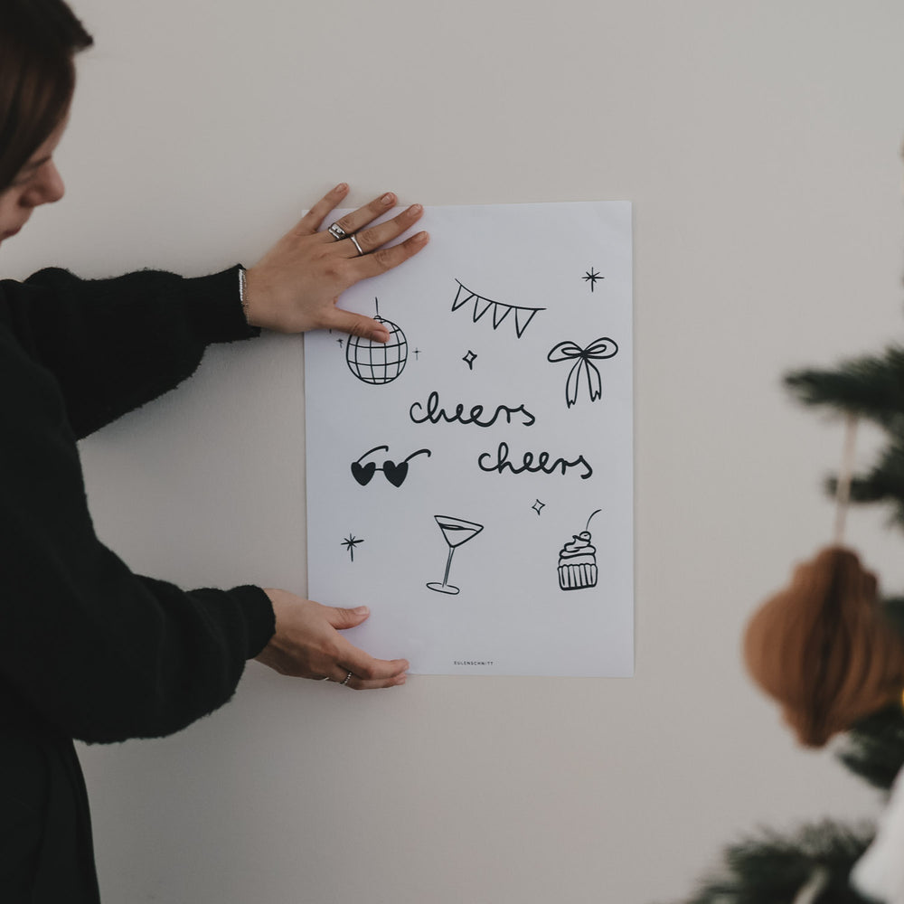 Frau hält Winter cheers Poster an die Wand. Modernes Poster für Küche, Esszimmer, Barbereich oder Homeoffice oder als geschmackvolles Geschenk zu Geburtstagen, Dinnerpartys oder Feiern aller Art.