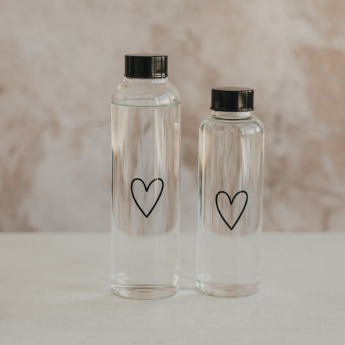 Zwei transparente Trinkflaschen aus Glas mit schwarzem Herz und schwarzem Schraubdeckel