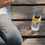 Trinkflasche aus Glas mit Herzprint neben Yogamatte im Outdoor-Setting