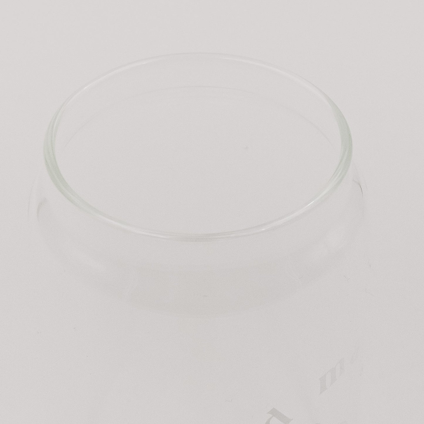 Der Rand von dem minimalistischem Glas in Detailaufnahme. Das minimalistische Design hebt sich vor einem hellen Hintergrund hervor.