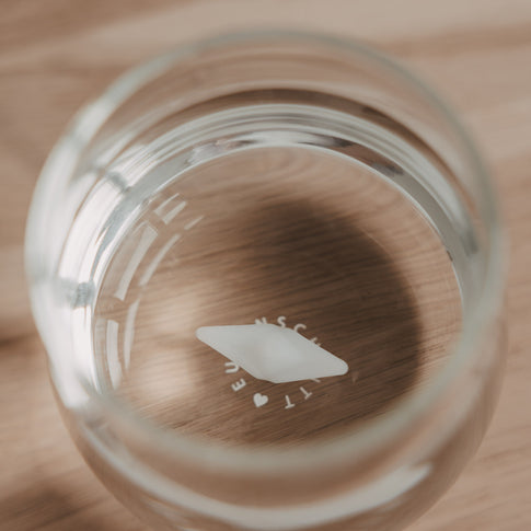 Draufsicht auf Glas mit Papierboot Detail im Boden, modernes Trinkglas Design