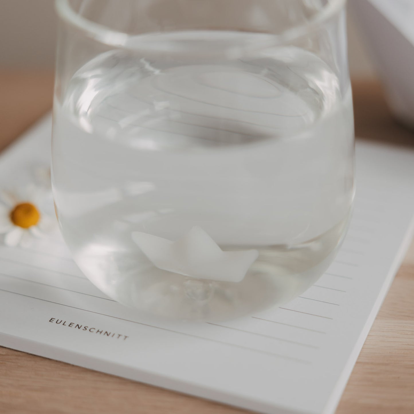 Detailaufnahme Papierboot im Glasboden mit Wasser, hochwertiges Trinkglas Design