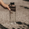 Glas Trinkflasche mit kleinen Herzen 750 ml, in der Hand gehalten, Sonnenlicht und Schatten im Freien