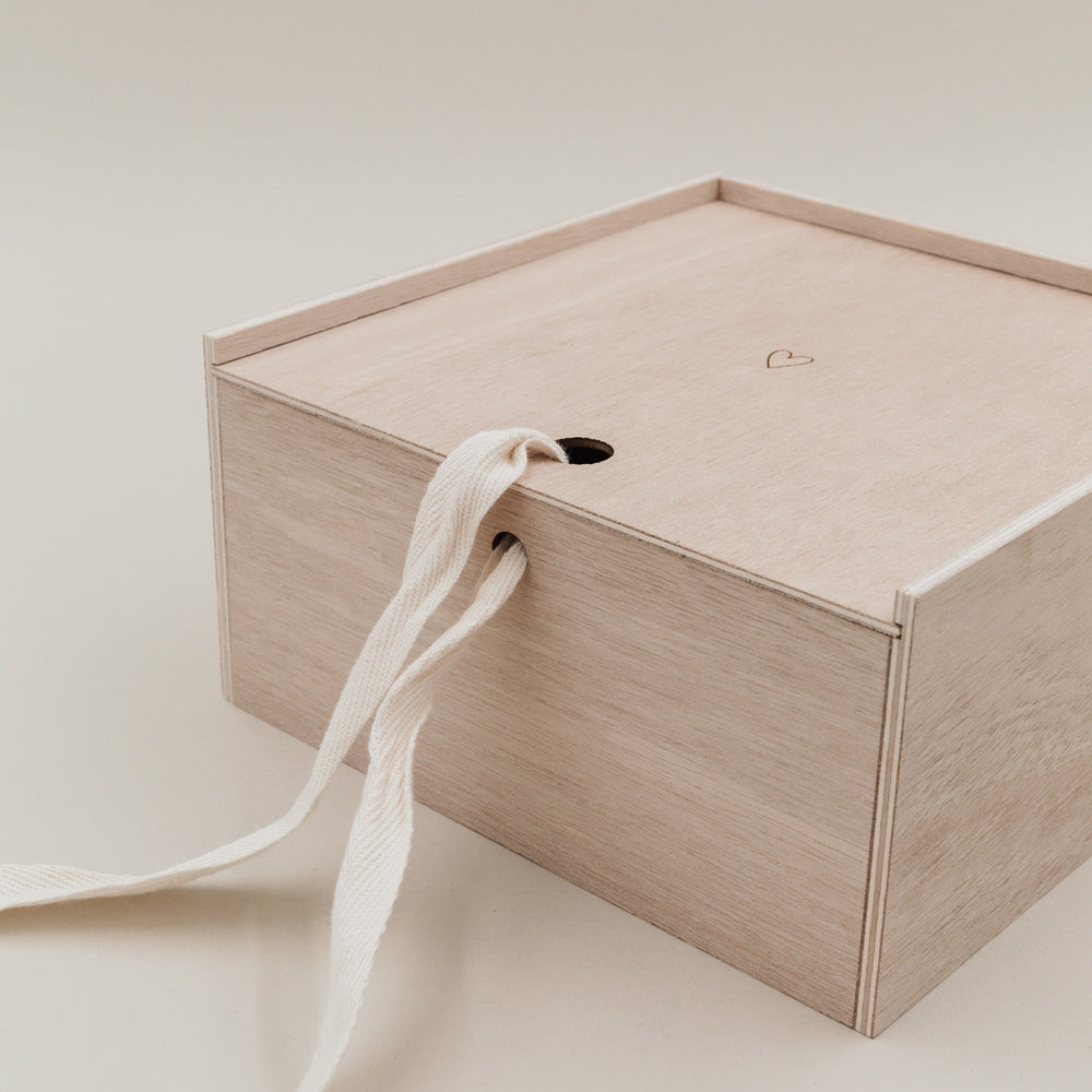 Nahaufnahme des geschlossenen Deckels der Erinnerungsbox Herz, durchzogen von einem Stoffband.