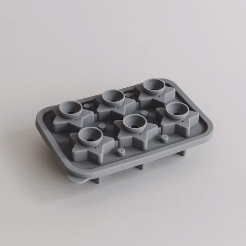 Geöffnete Eiswürfelform mit sternförmigen Kammern und runden Einfüllöffnungen in Draufsicht.
