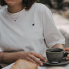 Detail weißes T-Shirt mit kleinem Herz-Print und Kaffeetasse