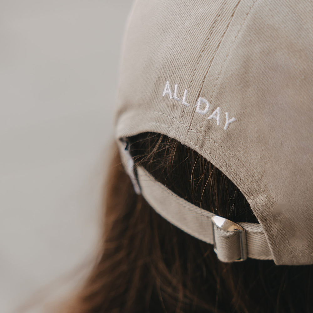 Detailansicht taupefarbene Cap mit Stickerei „ALL DAY“ und Metallverschluss