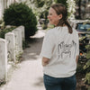Frau trägt weißes T-Shirt mit LOVE-Print auf dem Rücken, draußen fotografiert