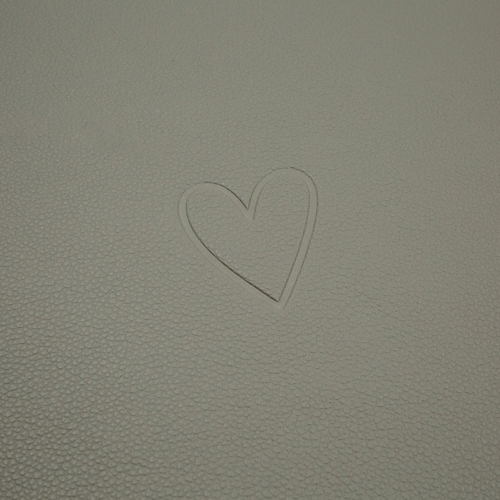 Prägung eines Herzsymbols auf der hellgrünen Oberfläche des wendbaren Platzsets Herz Grün.