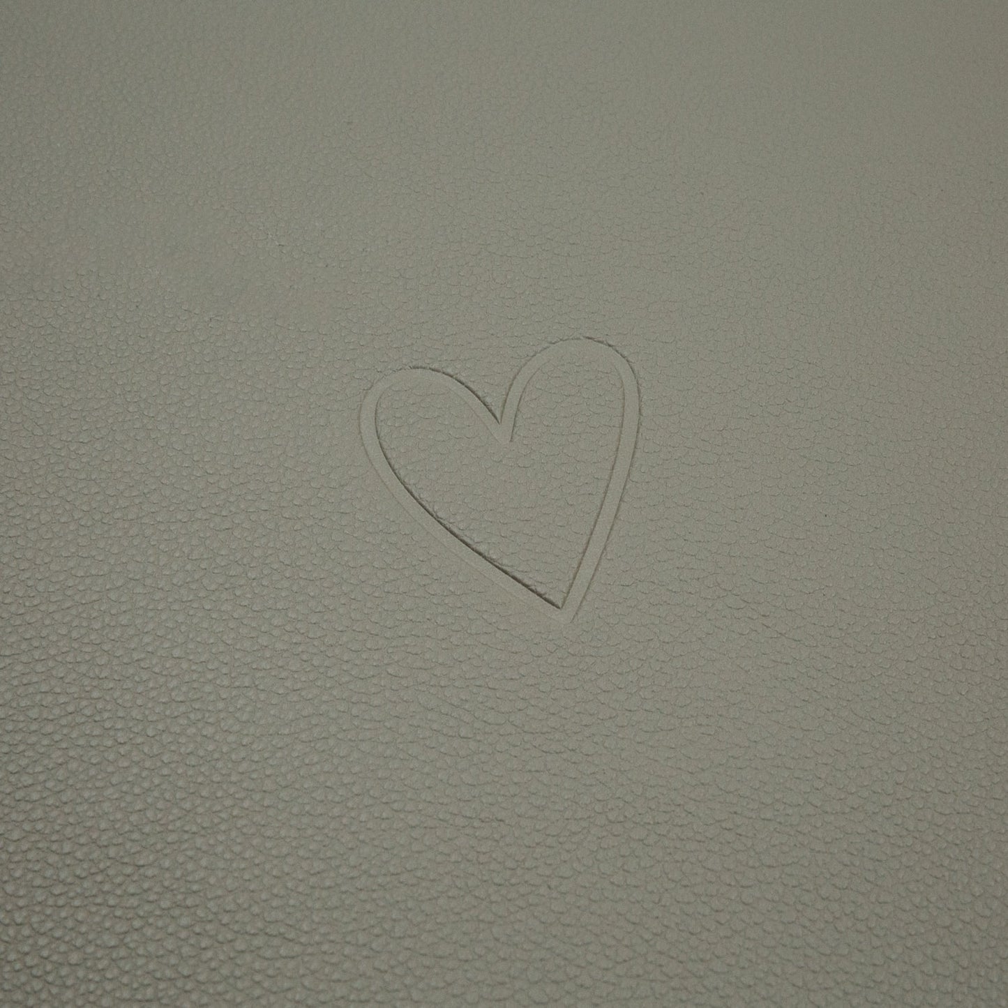 Prägung eines Herzsymbols auf der hellgrünen Oberfläche des wendbaren Platzsets Herz Grün.