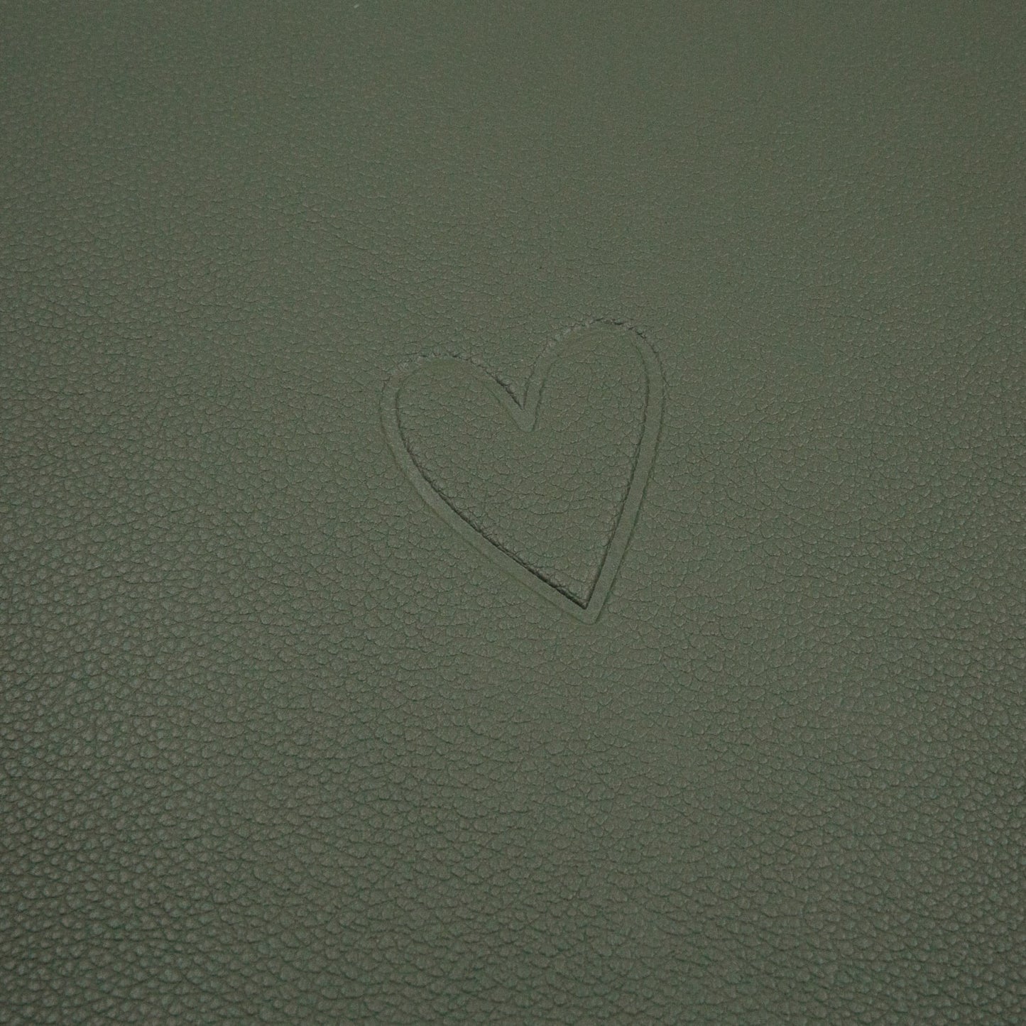 Eingeprägtes Herzmotiv auf der dunkleren grünen Seite des wendbaren Platzsets Herz Grün.