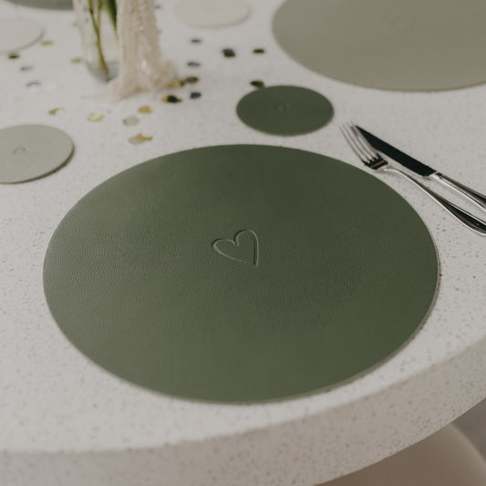 Wendbares Platzset Herz Grün in Dunkelgrün auf gedecktem Tisch mit eingeprägtem Herzmotiv.