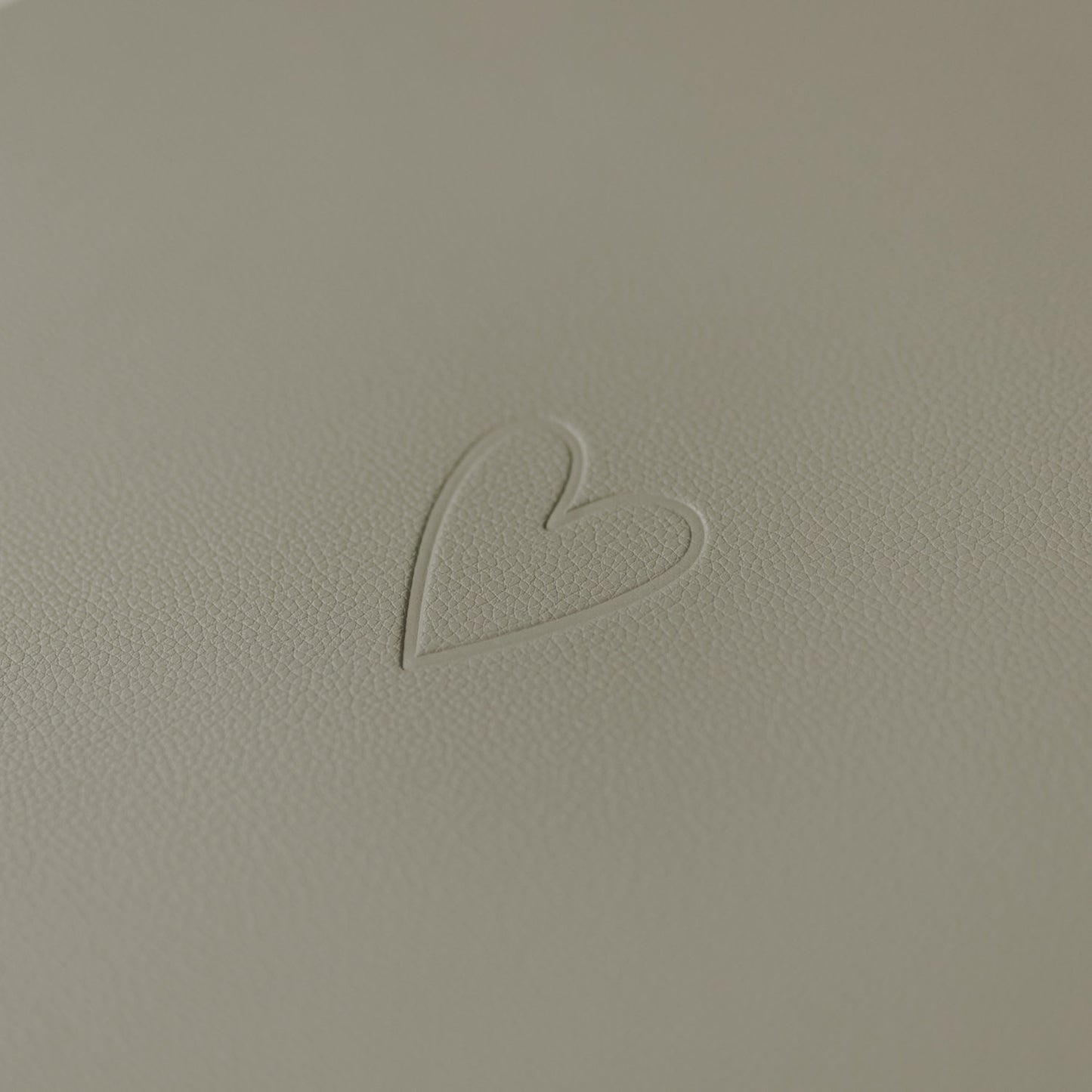 Nahaufnahme des eingeprägten Herzsymbols auf hellem grünen Platzset.