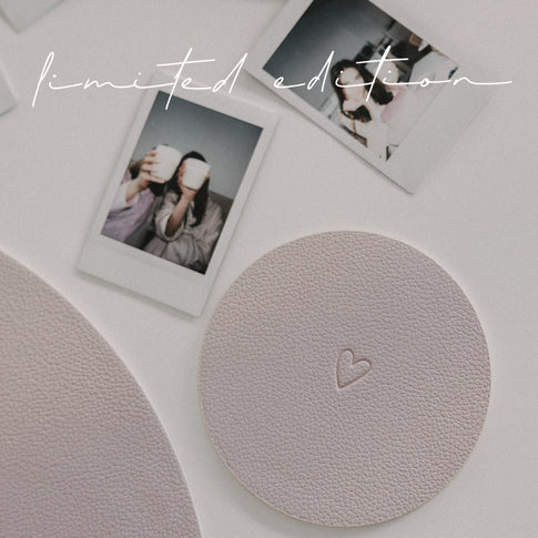 Runder Untersetzer Herz in Flieder mit geprägtem Herzmotiv, dekoriert mit Polaroidfotos.