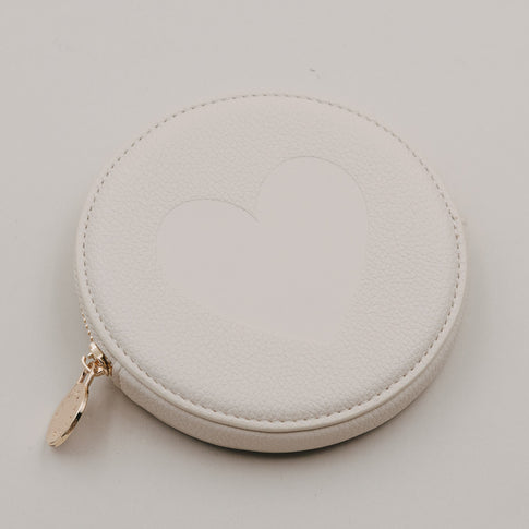 Rundes cremefarbenes Portemonnaie mit großem Herz auf der Vorderseite und goldenem Reißverschluss.