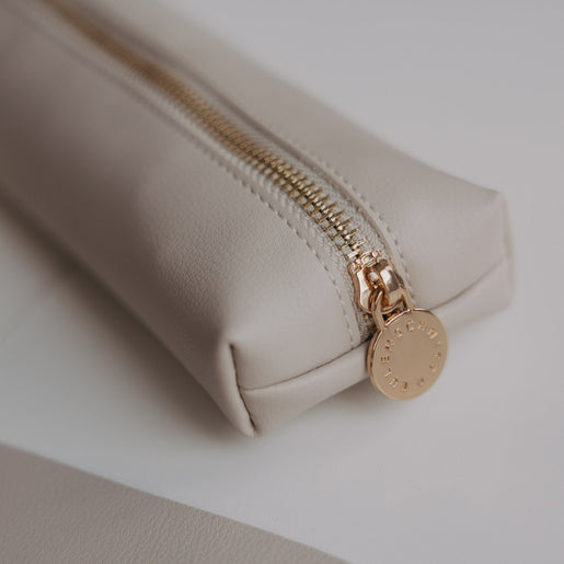 Detail der Federtasche in Taupe mit goldenem Reißverschluss und Eulenschnitt Anhänger