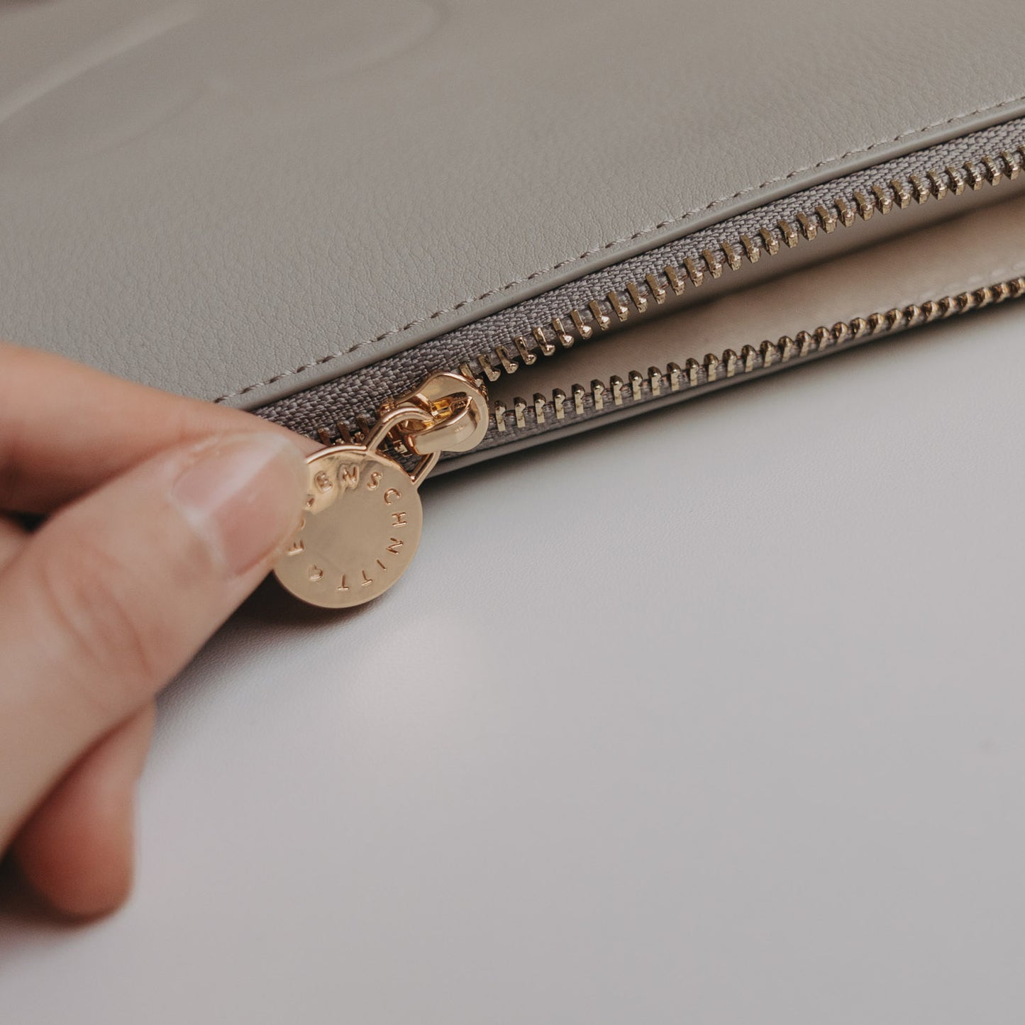 Detailansicht Reißverschluss des grauen Laptop Sleeves mit goldener Zipper-Münze von Eulenschnitt