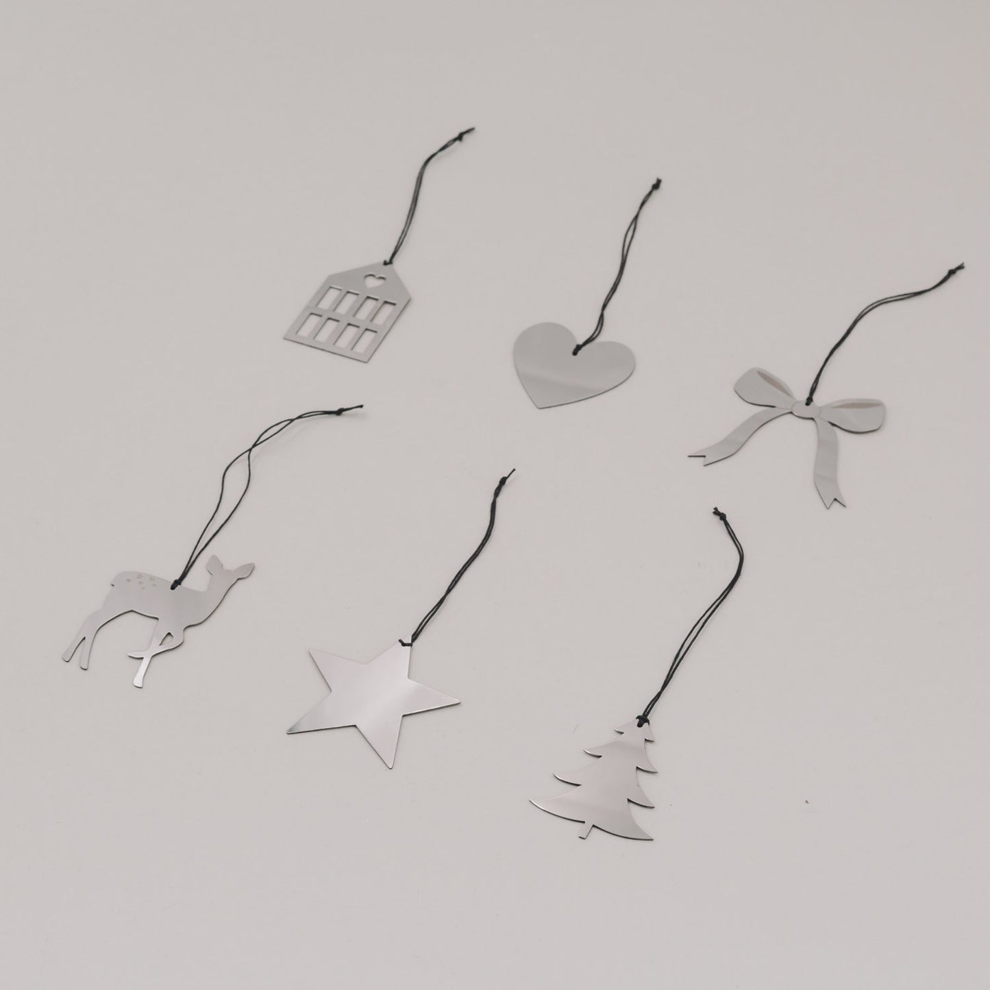 Sechs silberne Weihnachtsanhänger mit Band in Stern-, Herz- und Tierform