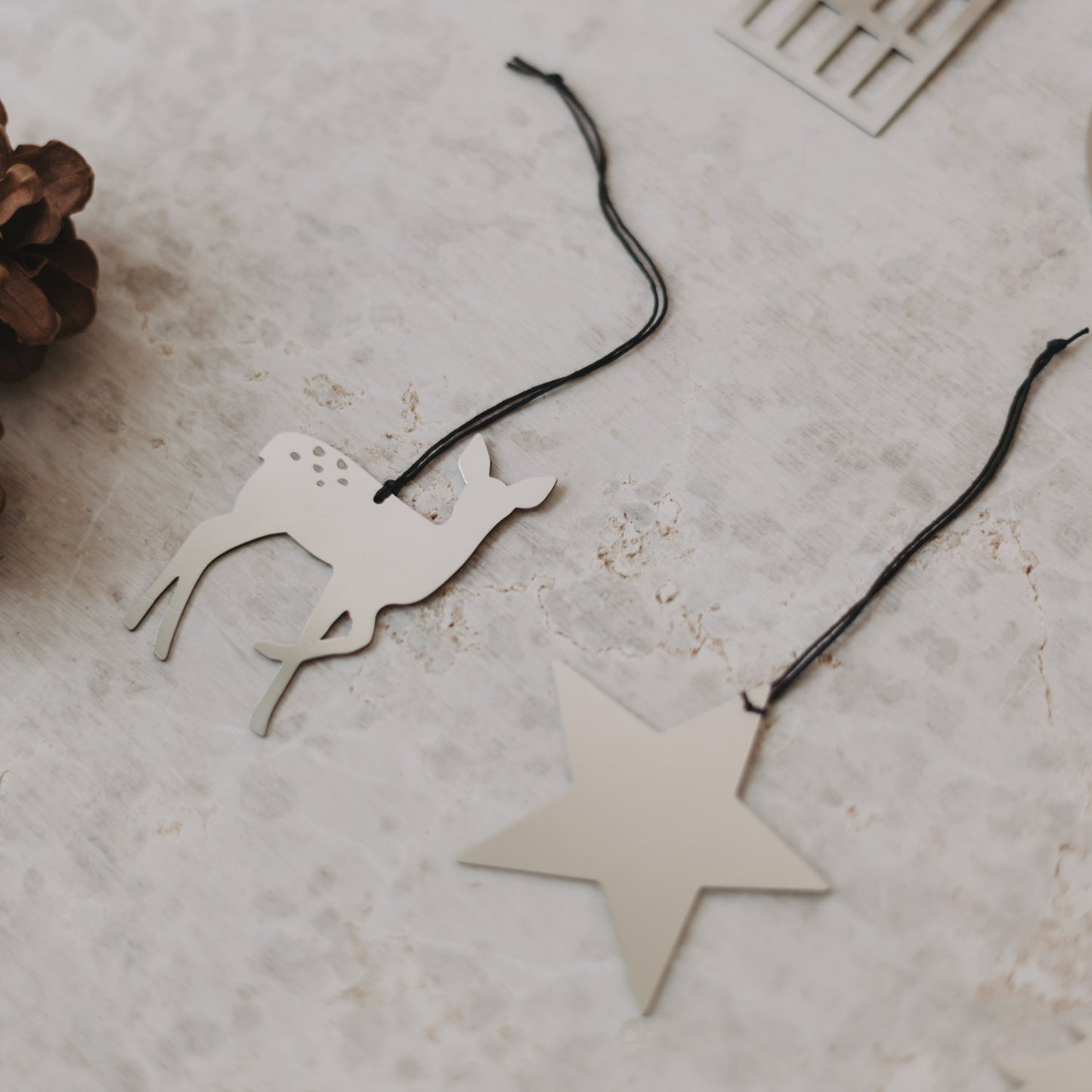 Nahaufnahme von Reh- und Sternanhänger auf hellem Untergrund