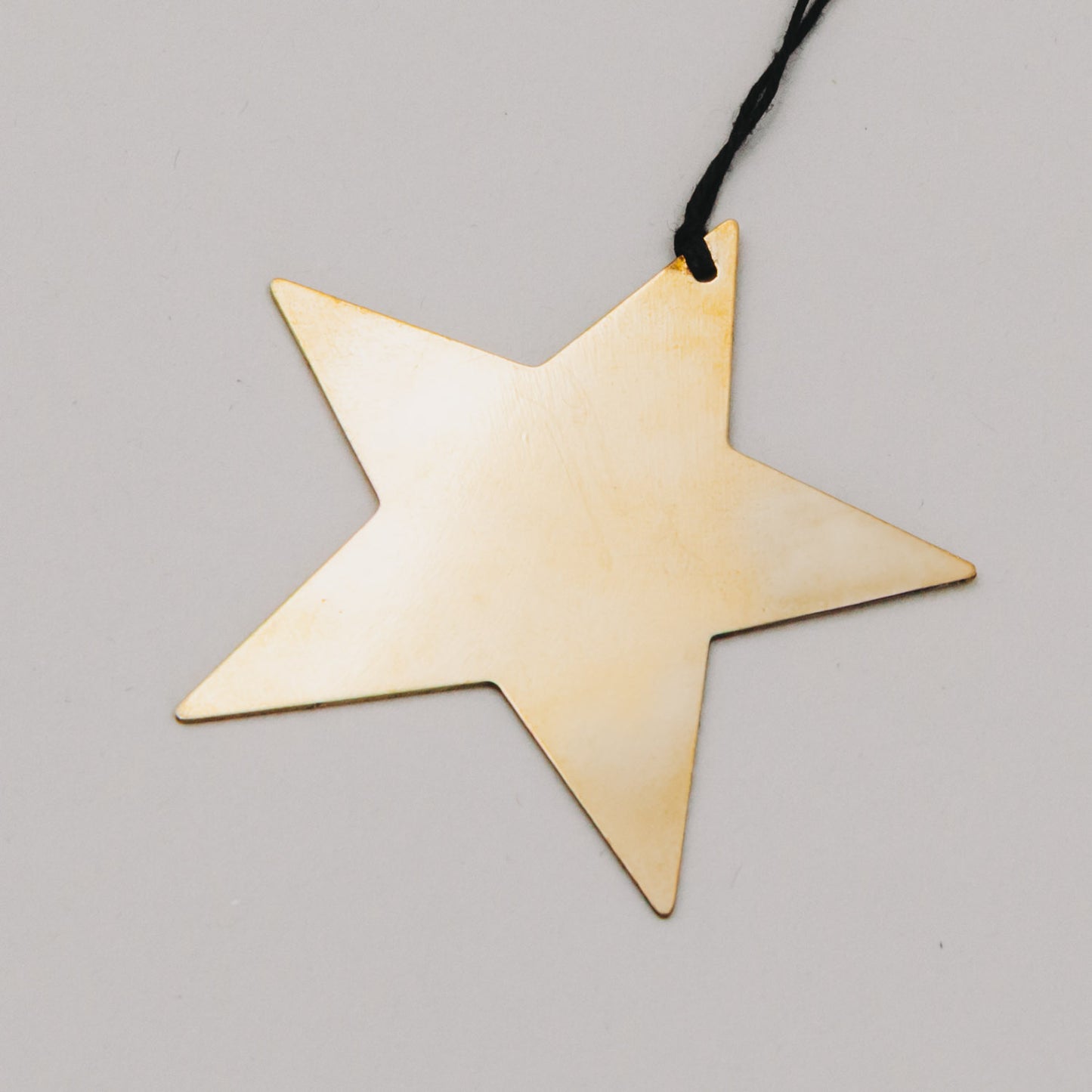 Nahaufnahme eines goldenen Sternanhängers mit feiner Struktur – schlichte Eleganz für festliche Dekoration.