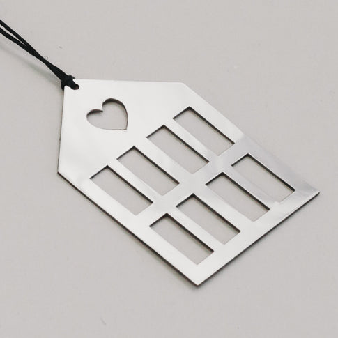 Detailaufnahme vom silbernen Metallhaus mit schwarzer Schnur, zeigt reflektierende Oberfläche.