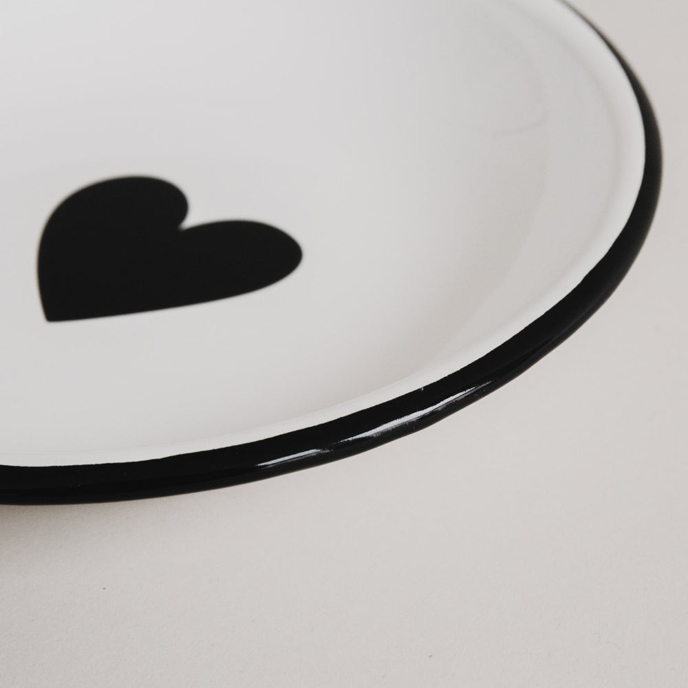 Detailaufnahme des Emaille Frühstückstellers Herz – schwarzer Rand und großes Herzmotiv im Fokus.