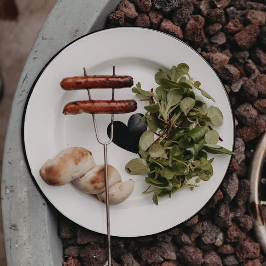 Emaille Speiseteller Herz mit Grillwürstchen, Brot und frischem Salat – stilvoller Teller für Outdoor-Mahlzeiten.